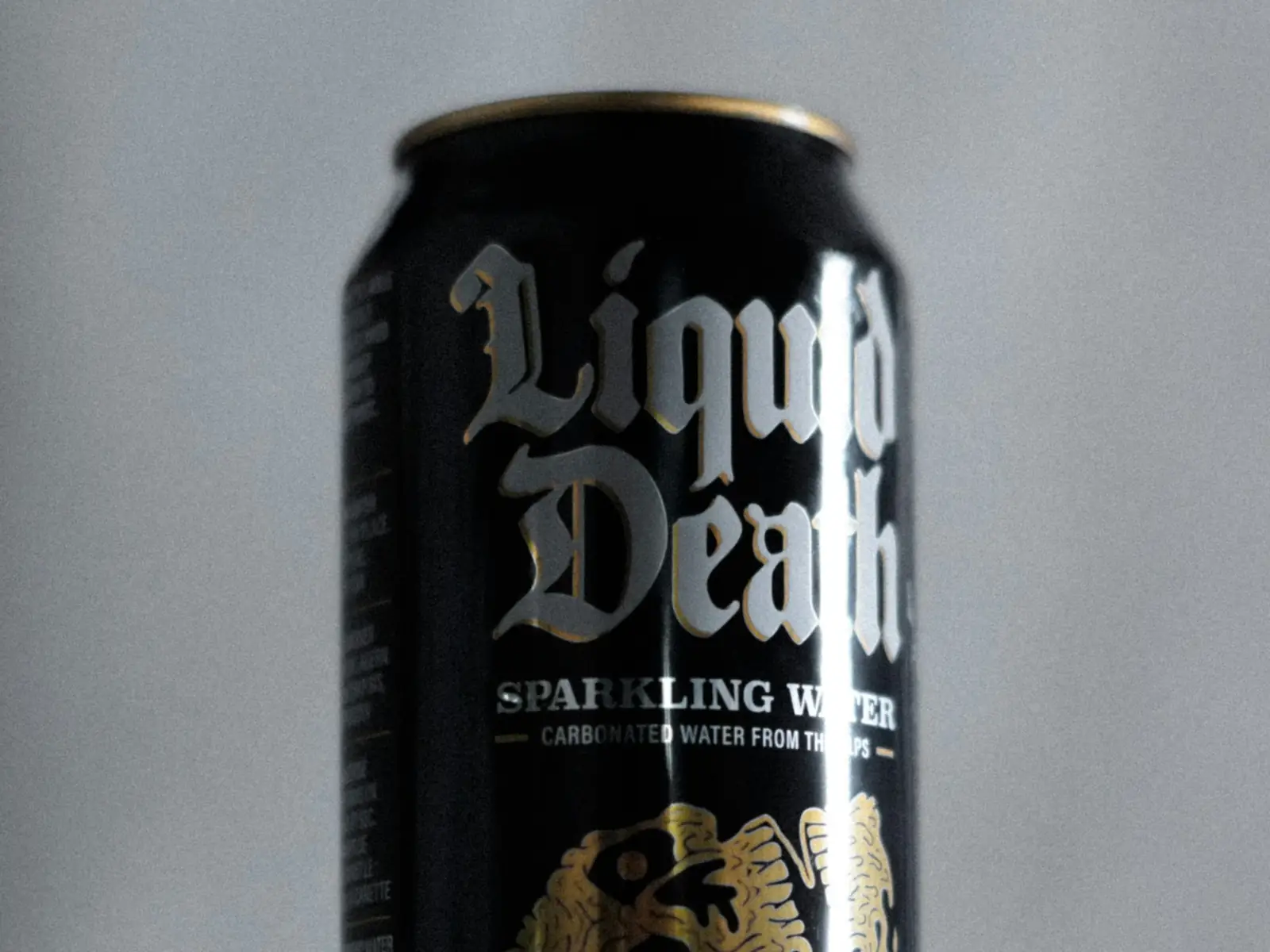 A black Liquid Death sparkling water can on a table